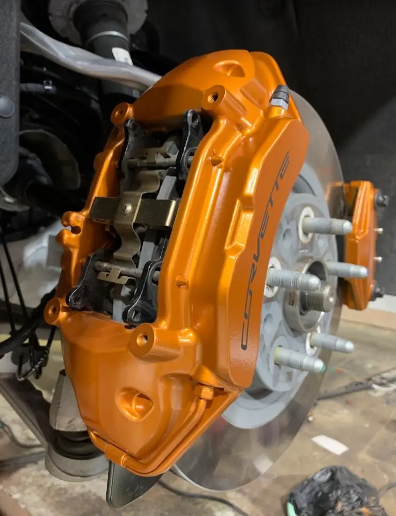 Close up of orange painted Corvette calipers